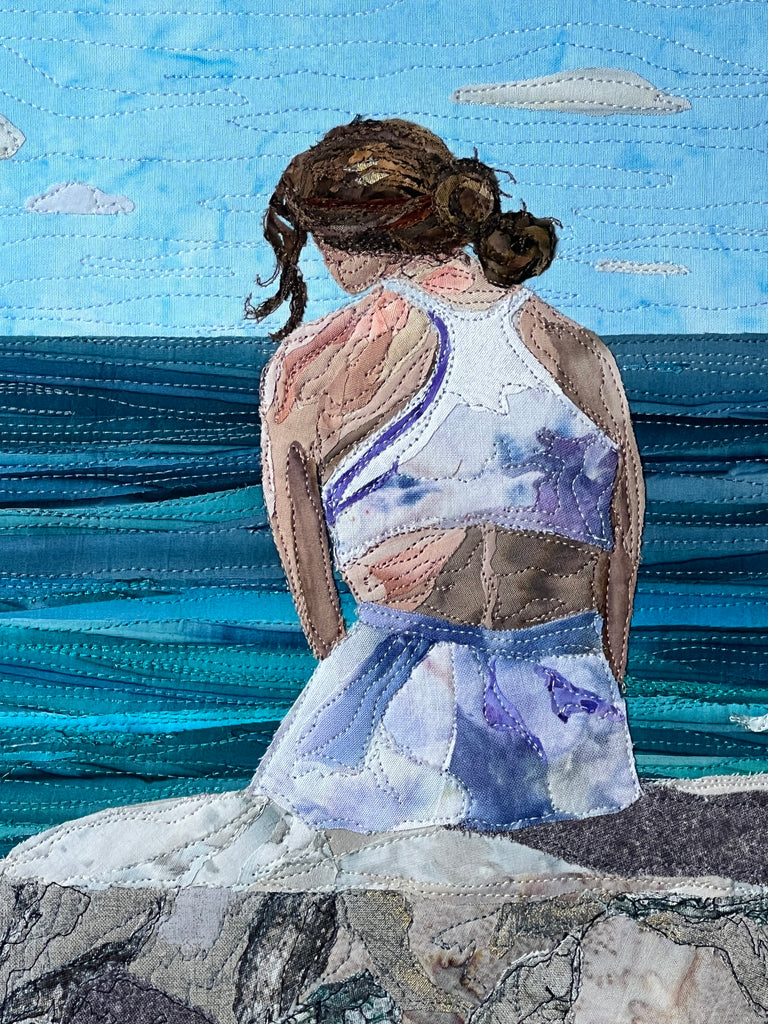 textile art of lady by ocean