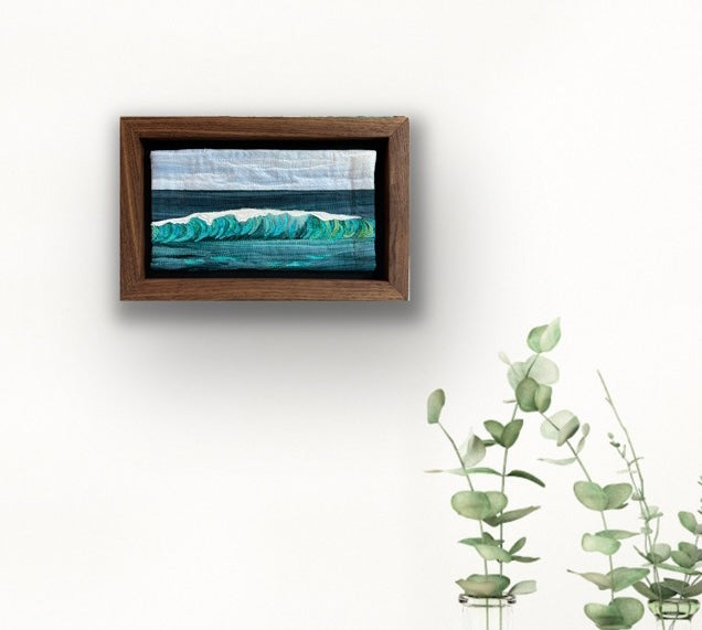 Ocean wave textile art framed in walnut.